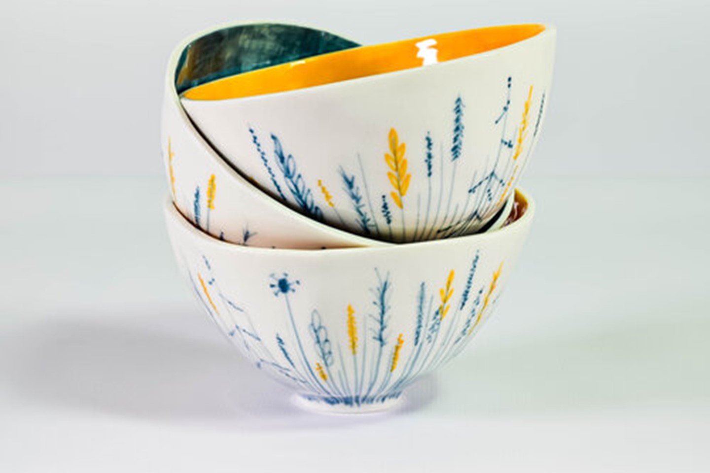 Photo of ceramic bowls, hand painted and decorated with yellow and blue leaves