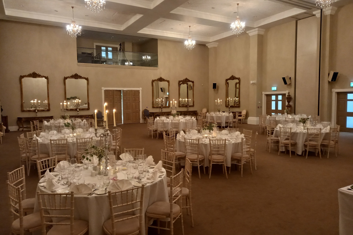 Versailles room set up for a wedding reception, with round tables 
