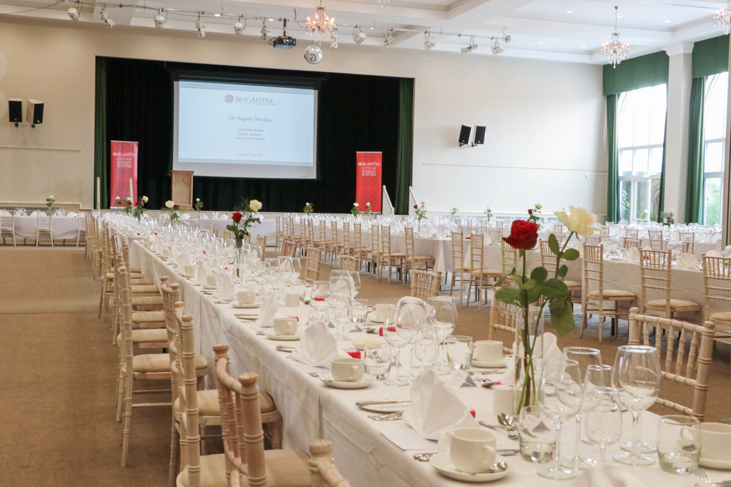 Long table setup for a private function, with red flower decoration